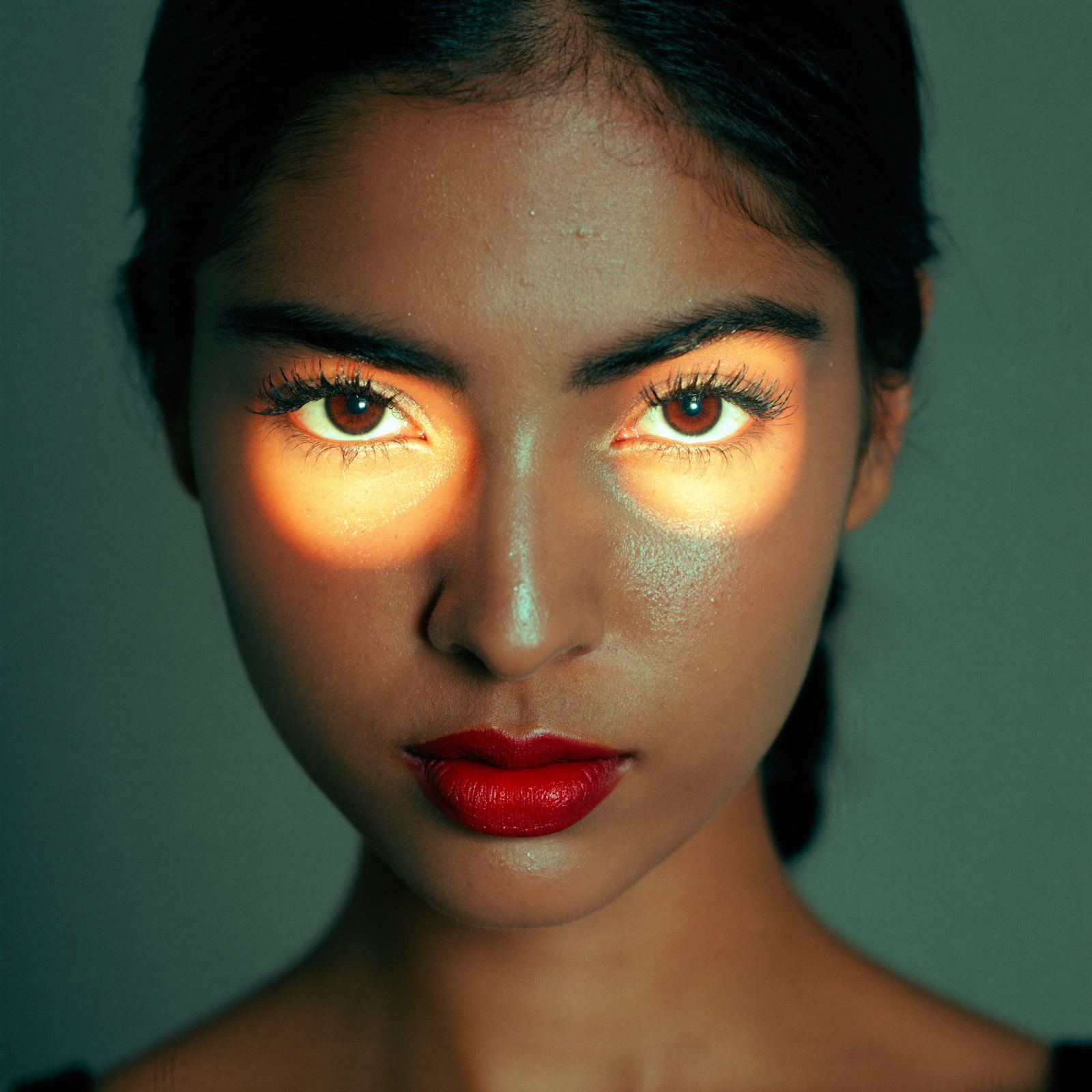 A close-up portrait with gold light across the eyes