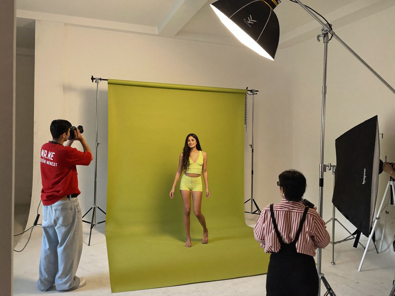 A photographer shooting a model against a lime backdrop